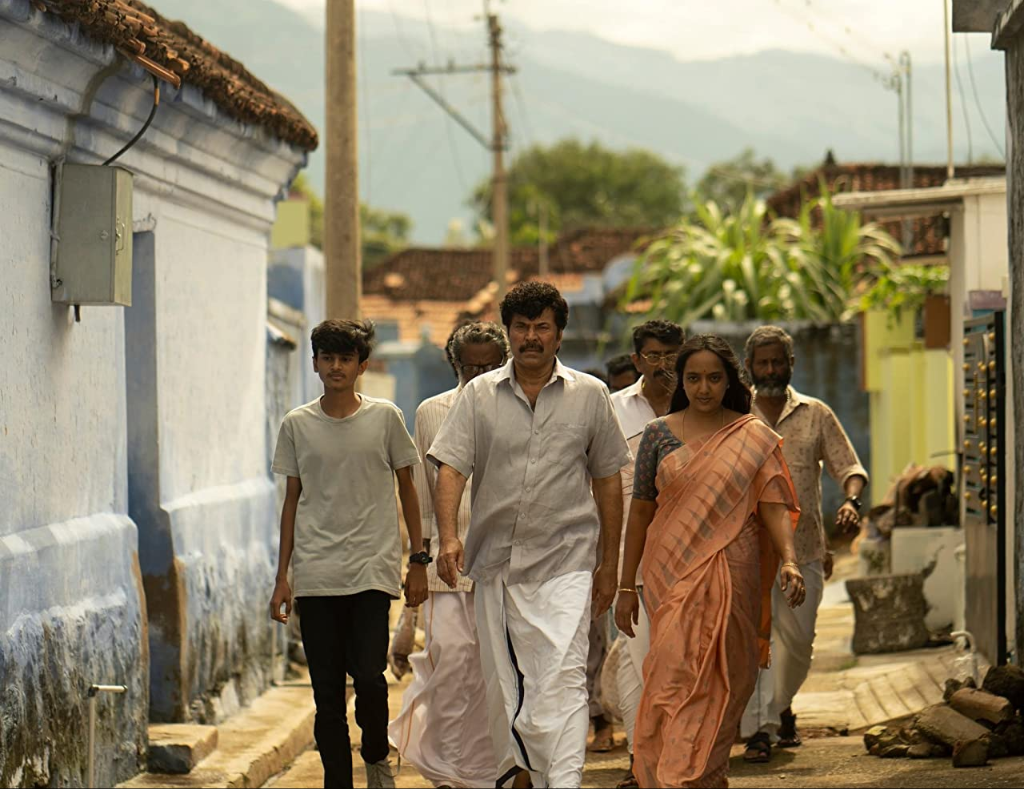 A group of people walk together through a peaceful village.