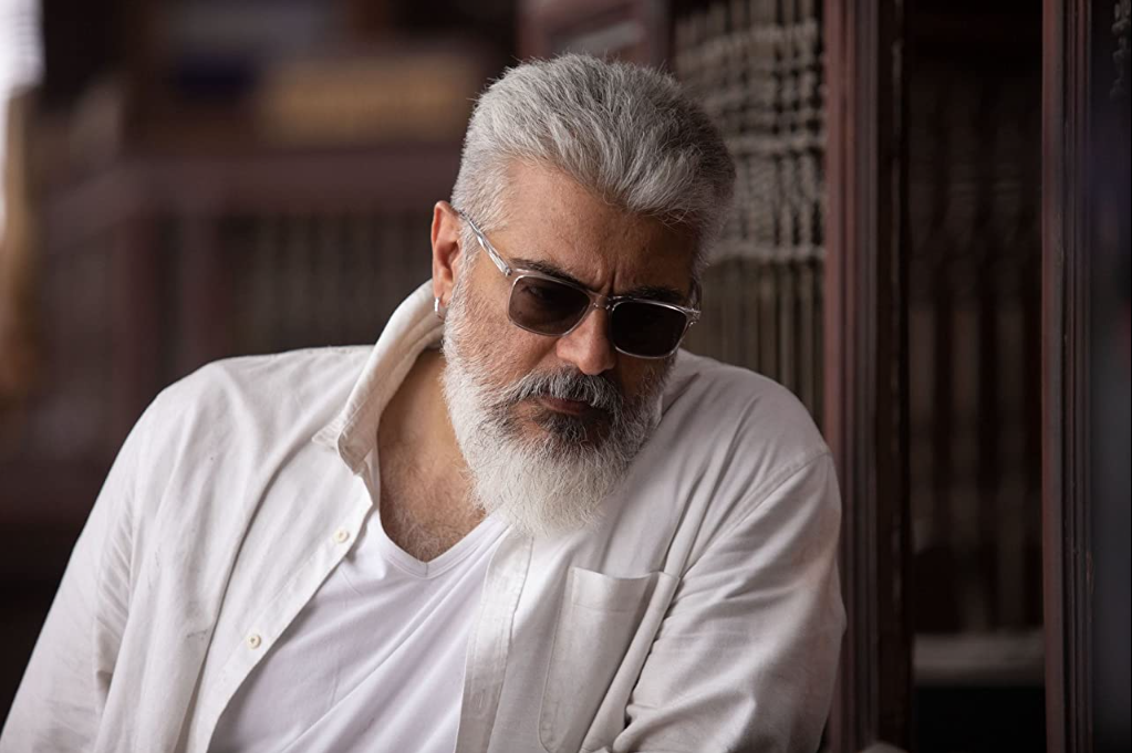 An older man with mostly white hair, but stylish and cool with dark sunglasses.