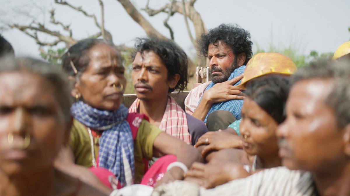 The fugitive father of the film Joram, riding in the back of a truck packed with passengers.