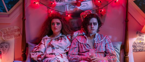 Lisa and her new corpse friend sit next to each other in her bed